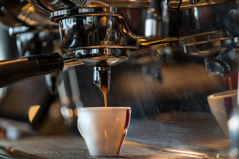 Espresso, der us dr Kafimaschine louft
